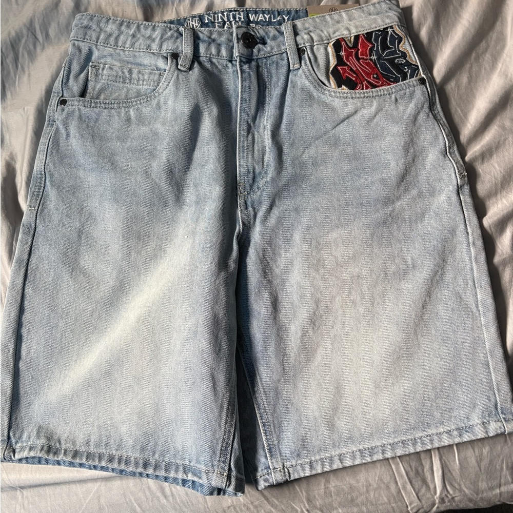 Ninth hall Jean shorts with embroidered designs on the front and back.